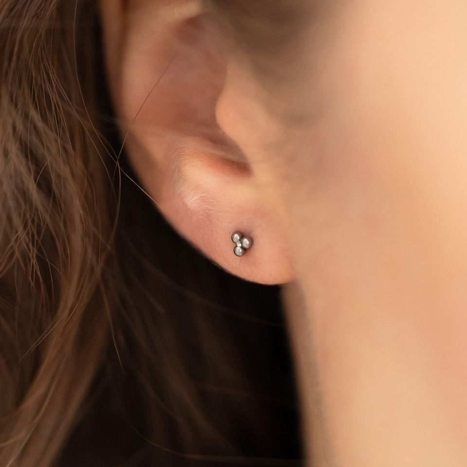 Įstumiamas titano labret auskaras su trikampiu rutuliukų dizainu